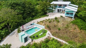 A modern resort with a pool, outdoor seating, and a view of the surrounding forest. - NEW! Stylish, Luxury Jungle Retreat with Saltwater Pool Samara Beach 5 mins (Sámara)
