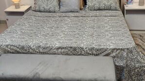 A bed with a patterned bedspread, two bedside lamps, and a nightstand with a tissue box. - Superb Urban Oasis in Almadies
 (Dakar)