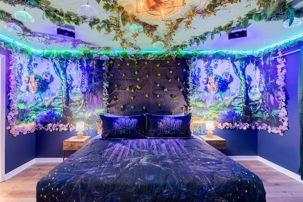 Quarto com cama, mesa de cabeceira e um mural na parede.