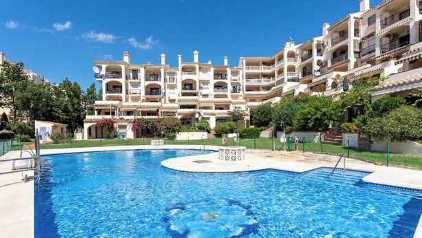 A swimming pool surrounded by a landscaped area with a multi-story building in the background. - Zeus Apartment Riviera del Sol by Costarentals - Ref 221 (Mijas)