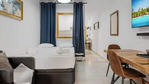 A hotel room with a bed, a dining table, and a sofa.