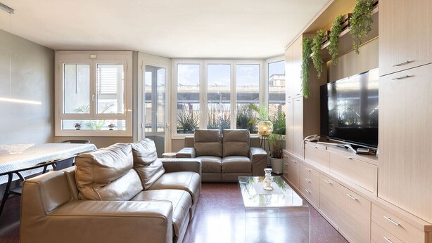 Een moderne woonkamer met een zithoek, een salontafel, een televisie en een eethoek.