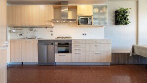 Een moderne keuken met roestvrijstalen apparatuur, houten kasten en een ingebouwde magnetron.