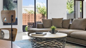Un salon moderne avec un canapé, une table basse ronde et une chaise en bois.