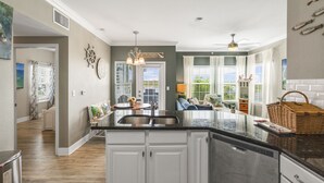 A spacious kitchen with a central island, white cabinetry, and a view to the dining area.
