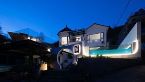 Un bâtiment moderne à deux étages, doté d’une entrée imposante et d’une piscine.