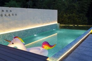 A swimming pool with a unicorn float and a rainbow float. - Yundan Fengqing Inn (Deqing)