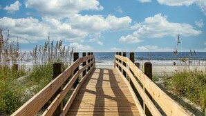 A wooden boardwalk leading to a beach with a clear sky and ocean in the background. - Premier Golf Location - Barefoot Resort! Family/dog friendly - 2 pools/beach! (North Myrtle Beach)