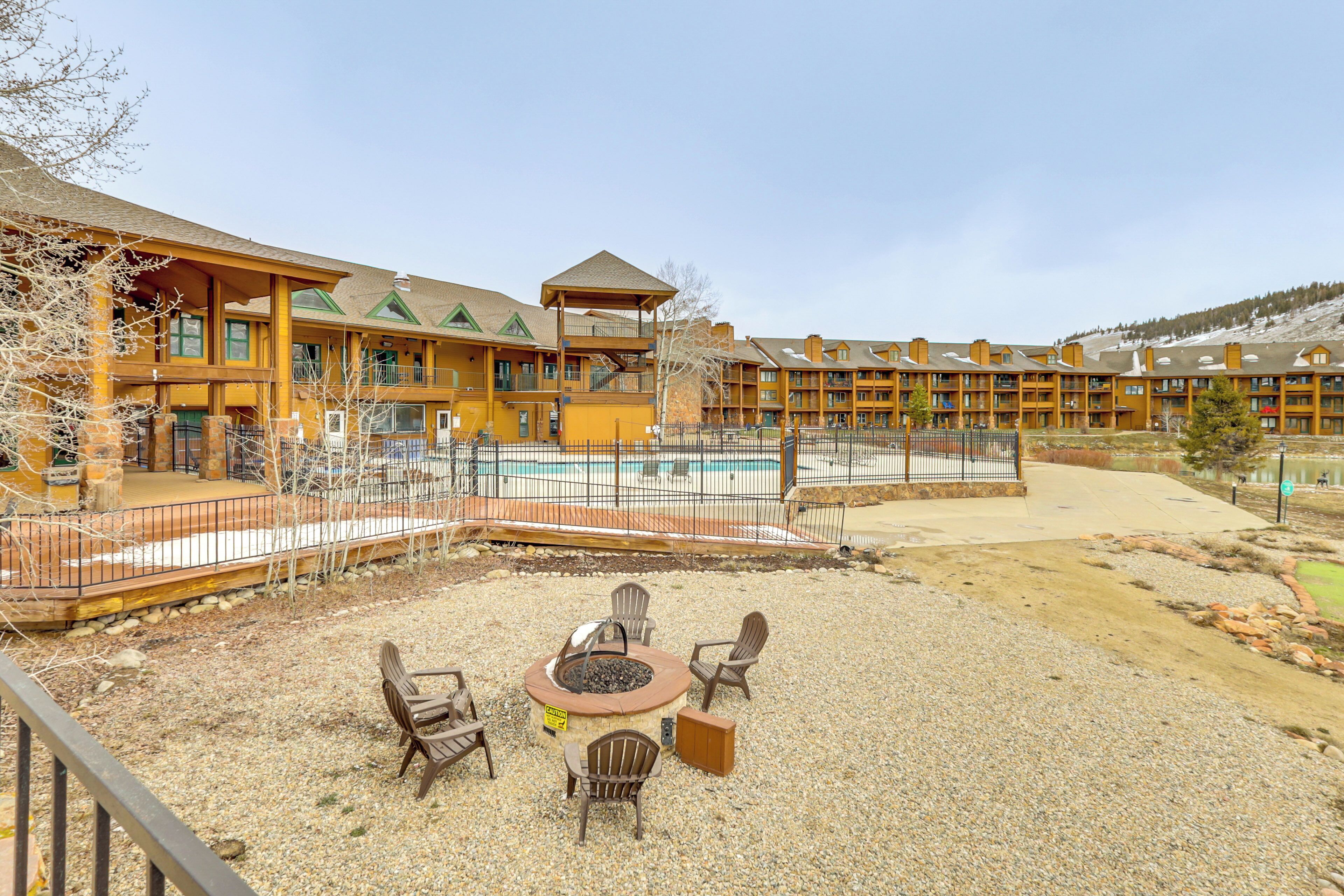 A lodge with a pool, outdoor seating, and a fire pit.