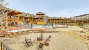 A lodge with a pool, outdoor seating, and a fire pit.
