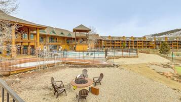 A lodge with a pool, outdoor seating, and a fire pit.