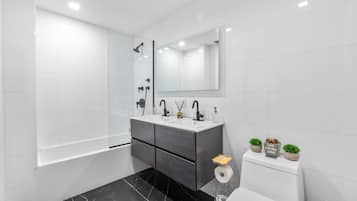 Un bagno moderno con una vasca, un water e un mobile lavabo con specchio.