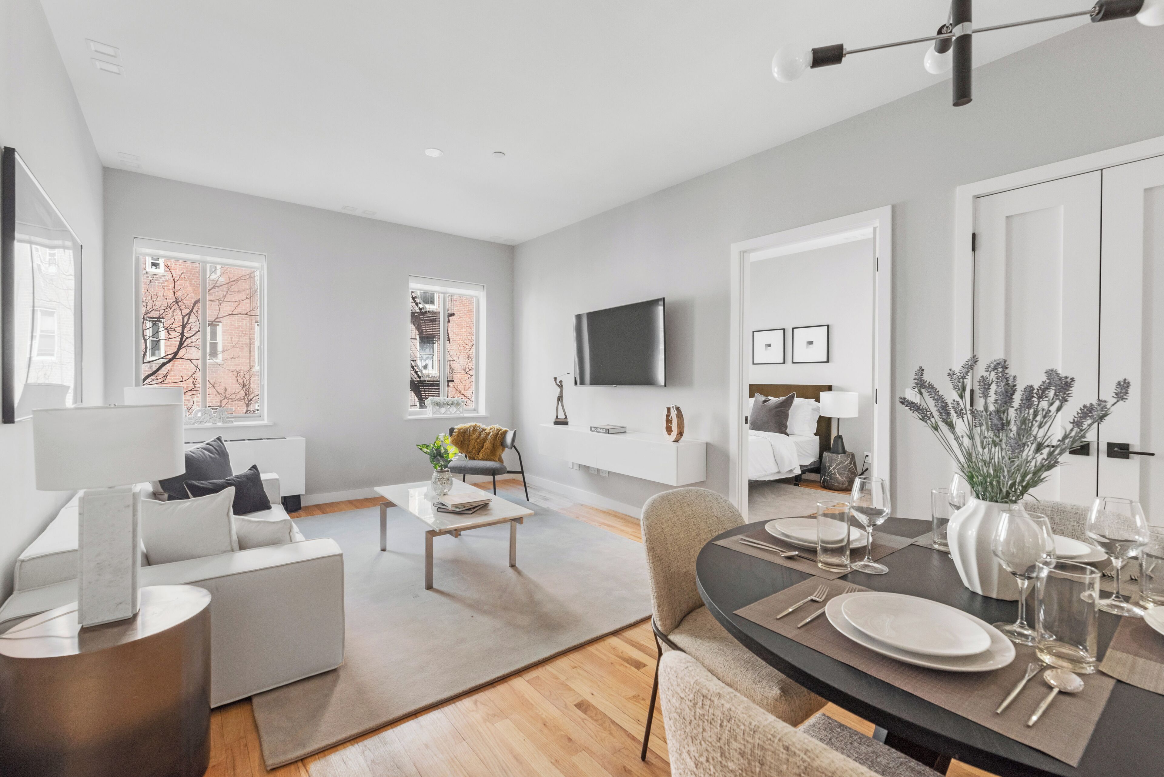A modern living room with a sofa, coffee table, and dining area set up for a meal.