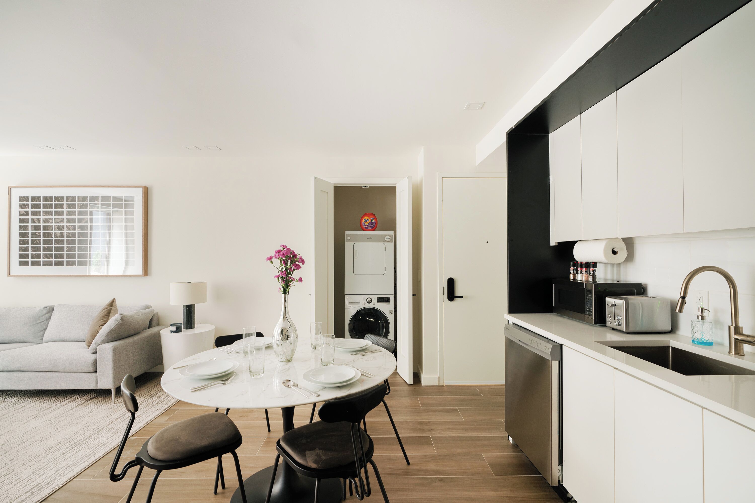 A modern kitchen with white cabinets, a dishwasher, and a microwave.