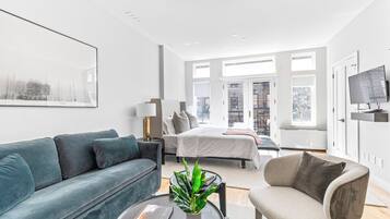 A modern living room with a sofa, armchair, and a coffee table with a plant.