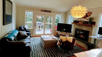 TV connectée, cheminée, livres, écrans d'ordinateur