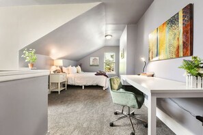 A modern bedroom with a sloped ceiling, a bed, a desk, and a chair. - Near Downtown & Stadiums! Hot Tub & Parking (Pittsburgh)