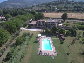 An aerial view of a large house with a swimming pool, surrounded by greenery and a hilly landscape. - Stunning Vacation Rental in Provincia di Perugia, Italy (Assisi)