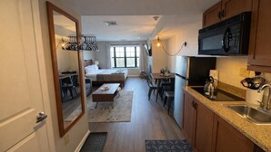 A compact hotel room with a kitchenette, a bed, a dining area, and a bathroom. - Heated Pool Hot Tubs Sauna Gym Mtn Views Appalachian @ Mtn Creek #225 (Vernon)