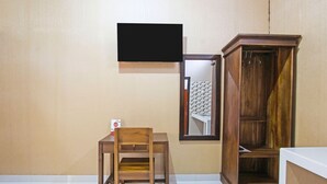 Une pièce comprenant une chaise en bois, un téléviseur fixé au mur et un meuble en bois.