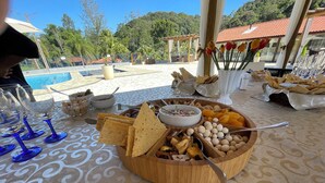 Une table de buffet proposant une variété de plats, avec une piscine en arrière-plan.