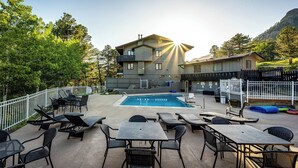 Ein Poolbereich mit Liegestühlen, einem Pool und einem Gebäude mit Balkon.