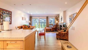 Een ruime woonkamer met keuken, eettafel en zitplaatsen.