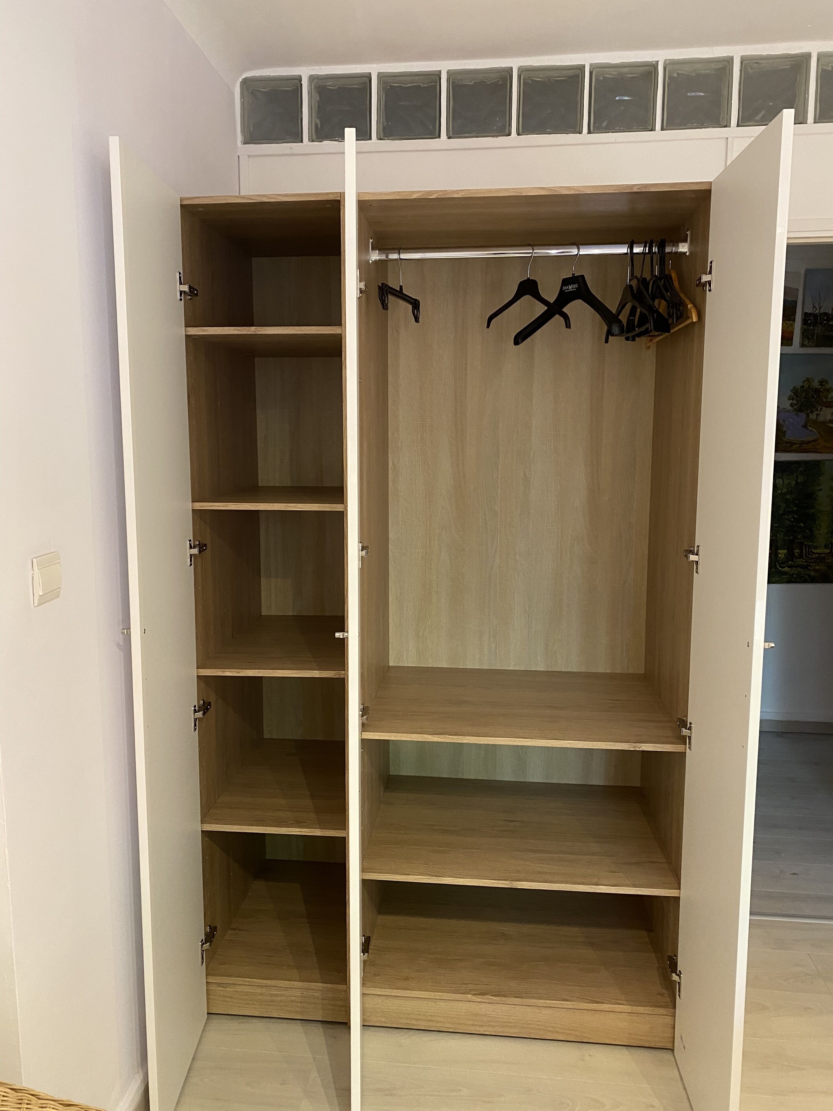 A walk-in closet with multiple shelves and hanging space.