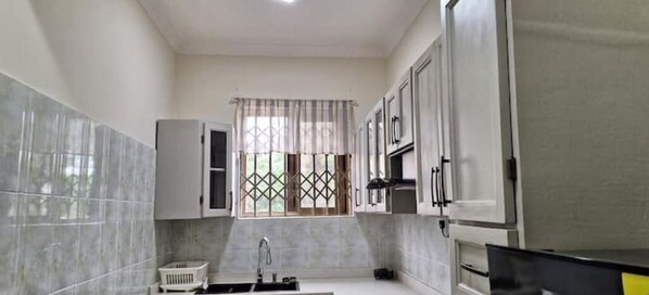 Enjoy cooking in this well-maintained kitchen with a central island, sink, and cabinets.
