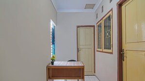 Een gang met een houten tafel, een deur en een raam met uitzicht.
