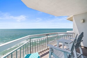 Un balcon avec vue sur l’océan, un panneau indiquant « il est interdit de fumer » et du mobilier d’extérieur.