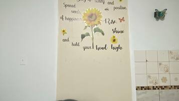 A wall with a motivational quote and a sunflower decoration.