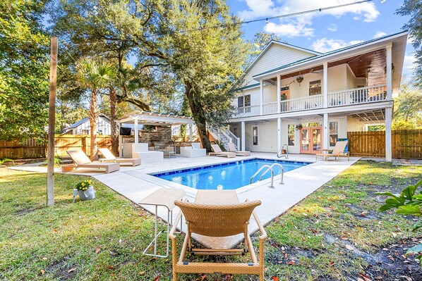 Une maison à deux étages dotée d’une piscine, d’un espace extérieur aménagé et d’une terrasse couverte.