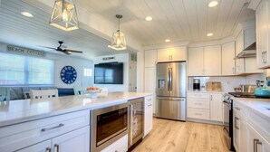 A modern kitchen with white cabinetry, stainless steel appliances, and a central island. - Stone Harbor Bar on the Bay (Middle Township)