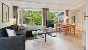 A modern living room with a sofa, coffee table, TV, and dining area. - Amazing home in Gørlev with WiFi (Gørlev)