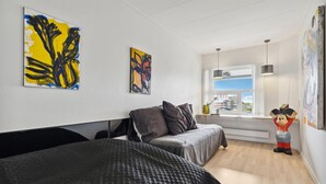 A modern hotel room with a bed, a window with a view, and abstract art on the walls. - Gorgeous apartment in Fanø with WiFi (Fanø)
