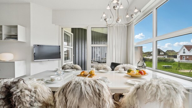 A modern dining room with a large window, a chandelier, and a view of the countryside. - Gorgeous apartment in Fanø with WiFi (Fanø)