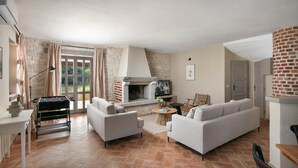 A cozy living room with a fireplace, sofas, a foosball table, and a television. - 4 bedroom nice home in Sveti Lovrec (Sveti Lovrec)