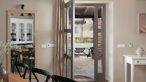 A dining area with a wooden table and chairs, a kitchen with cabinets, and a view of a pool and outdoor seating. - 4 bedroom nice home in Sveti Lovrec (Sveti Lovrec)