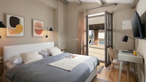 A bedroom with a bed, bedside tables, a desk, a chair, a TV, and a view of the outside. - 4 bedroom nice home in Sveti Lovrec (Sveti Lovrec)