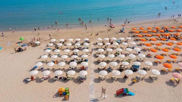 A beach with rows of umbrellas and sun loungers, a lifeguard tower, and a playground. - Lovely apartment in Roseto degli Abruzzi (Roseto degli Abruzzi)