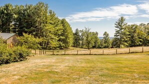A rural landscape with a wooden barn, a fenced field, and a variety of trees. - Quiet, off the grid getaway with access to hiking, fishing and wineries nearby! (Bridgewater)