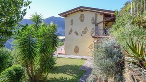A building with a stone facade, a balcony, and a mountain view.