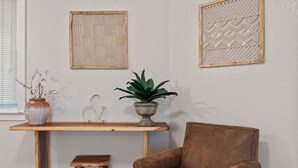 A room with a wooden table, a brown leather chair, and two wall-mounted decorative panels. - 2BR Downtown Sac - In unit Laundry - Free Parking (Sacramento)