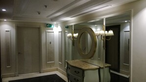 A hotel bathroom with a large mirror, a vanity with a marble countertop, and a black marble floor. - San Stefano Grand Plaza (Alexandria)