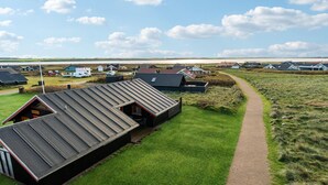 Un entorno rural con una hilera de cabañas y un vasto campo abierto.