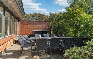 Enjoy al fresco dining on the patio surrounded by lush greenery and trees.