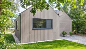 A modern, single-story building with a large window and a sloped roof. - Lovely home in Oosterwolde with WiFi (Oosterwolde)