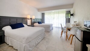 A hotel room with two beds, a desk, and a television. - State of the arts family unit best location beach & pool (CancÃºn)