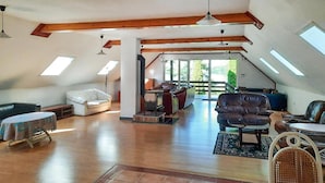 Un loft amplio con techos altos, vigas de madera a la vista y grandes tragaluces.
